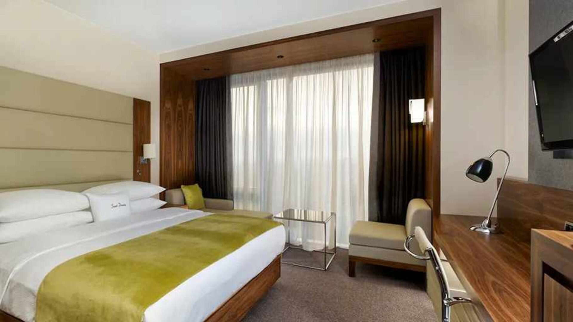 spacious king suite with TV, work desk, chair, and lounge area at DoubleTree by Hilton Zagreb.