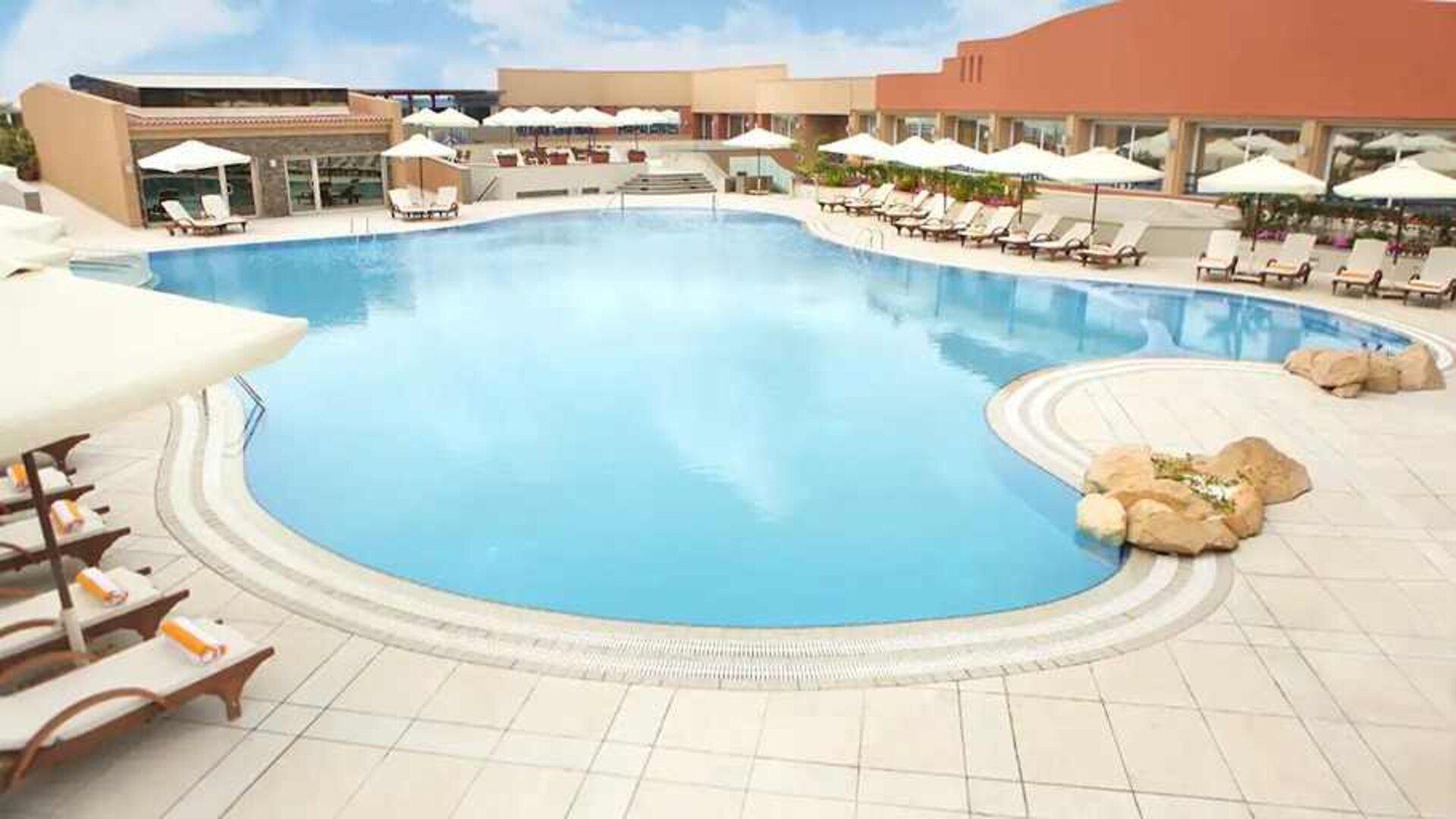 stunning outdoor pool with sunbeds and umbrellas at Hilton Alexandria Green Plaza.