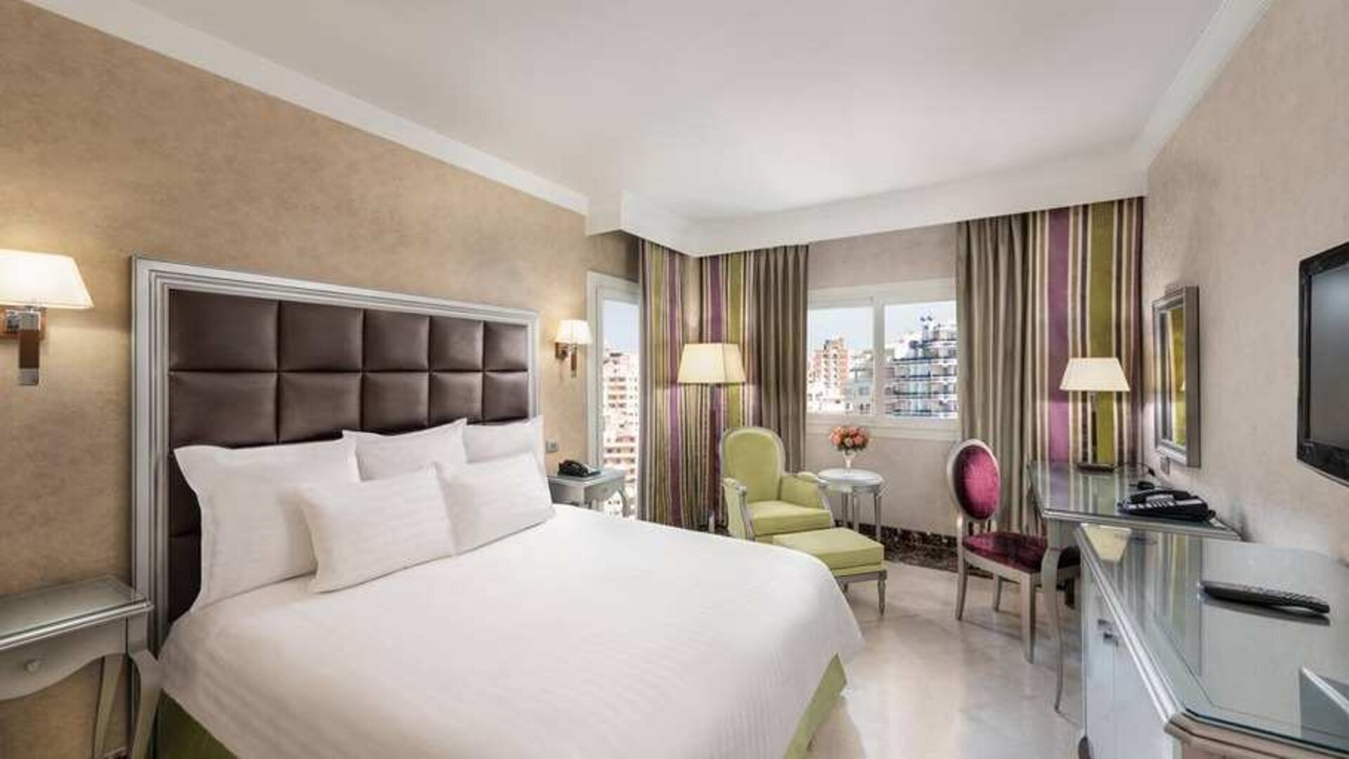 spacious king room with TV, desk, chair, and couch at Hilton Alexandria Corniche.