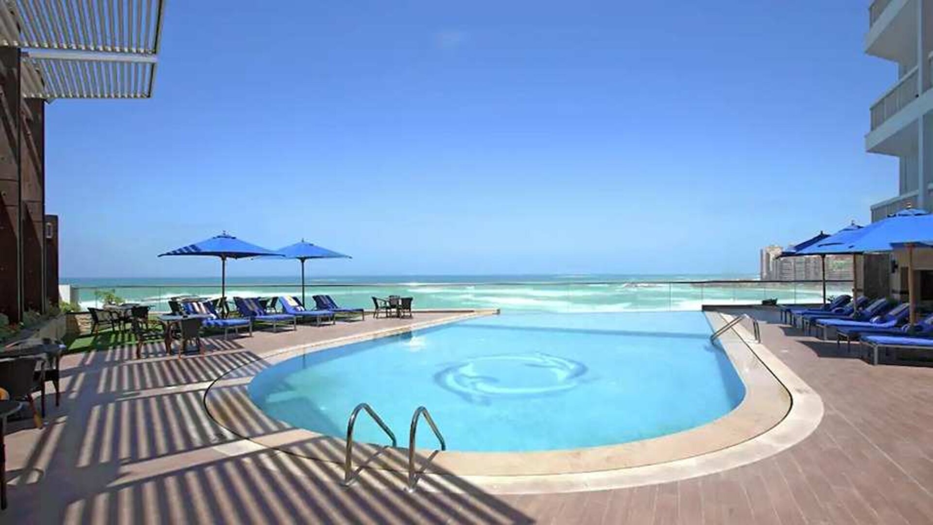 stunning outdoor pool with sunbeds and umbrellas at Hilton Alexandria Corniche.