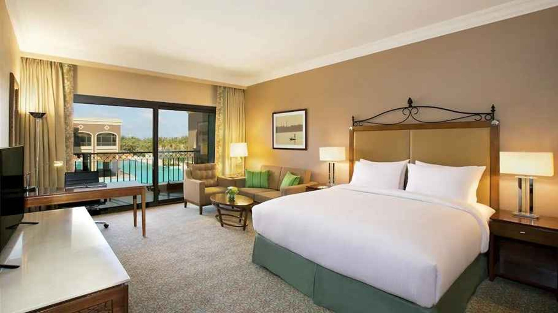 luxurious king room with TV, desk, chair, and lounge area at Hilton Alexandria King's Ranch.