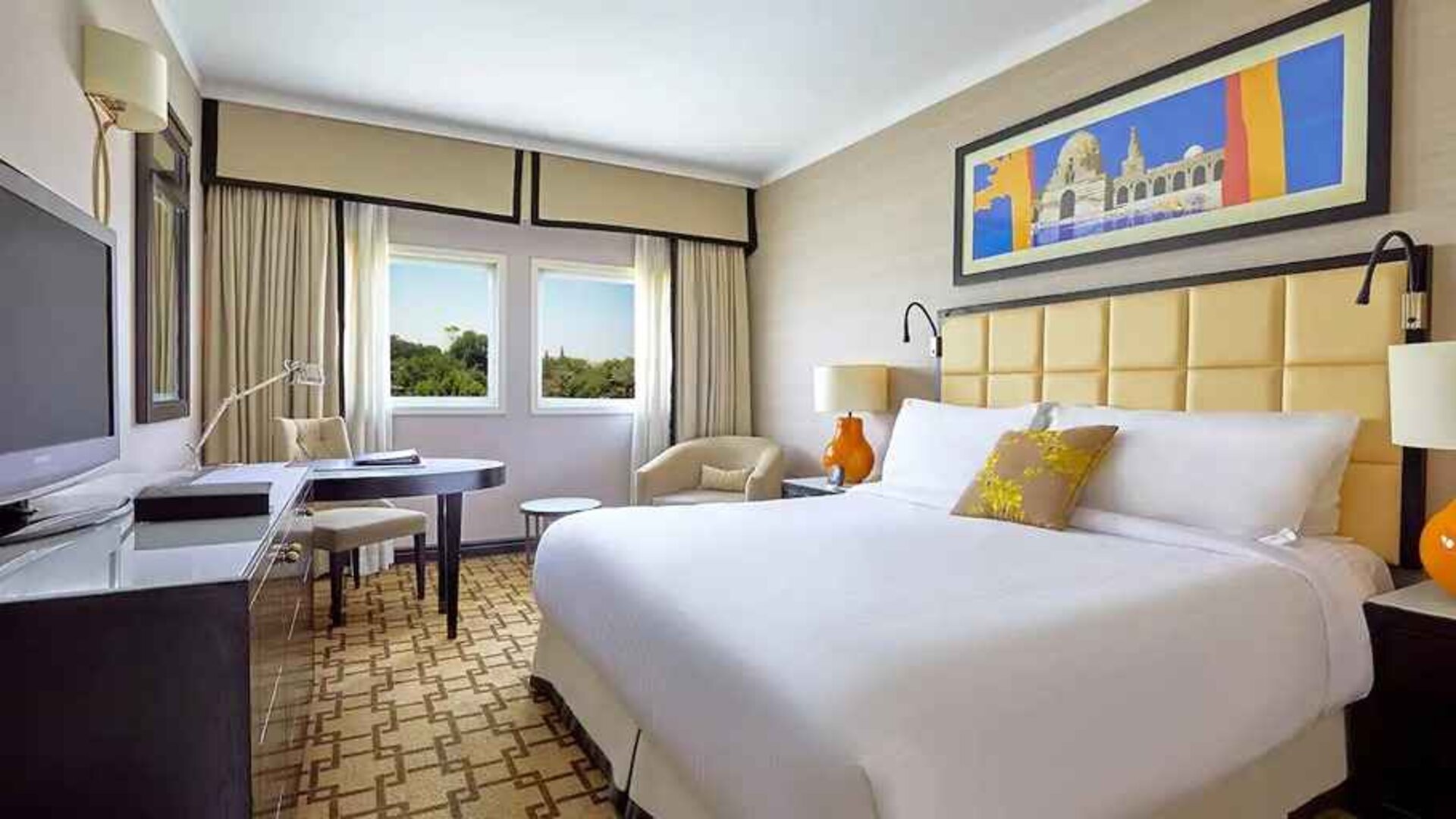 delux king room with TV, desk, chair, and couch at Hilton Cairo Heliopolis.