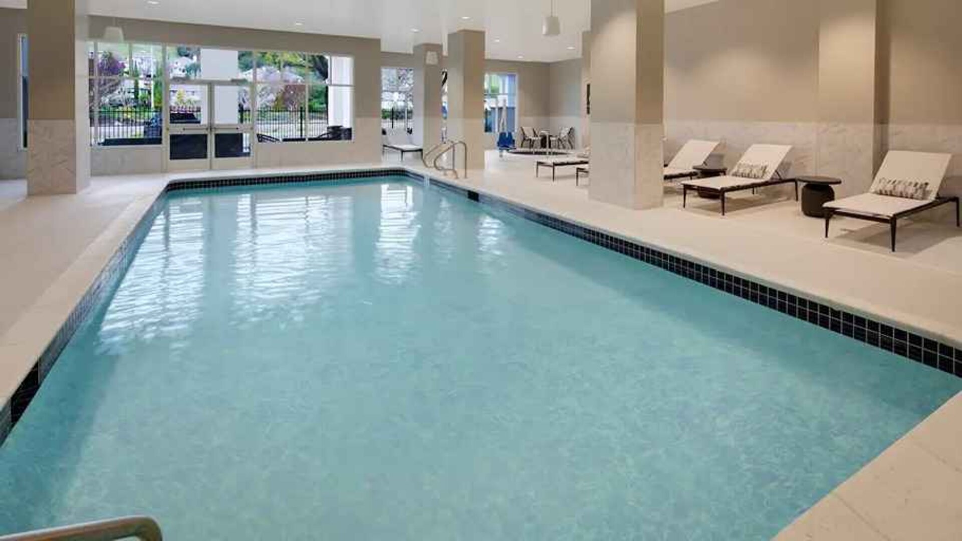 Gorgeous indoor pool with sun beds and seating at Embassy Suites by Hilton San Rafael Marin County.