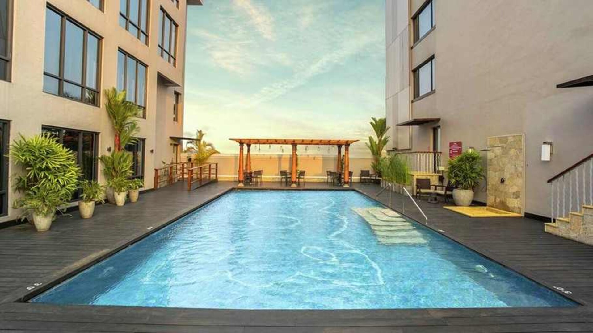 stunning outdoor pool with seating area at Hilton Garden Inn Trivandrum.