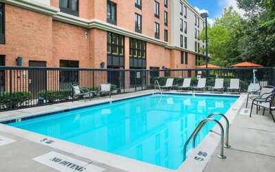 large outdoor pool with sunbeds and outdoor seating at Hampton Inn & Suites Annapolis.