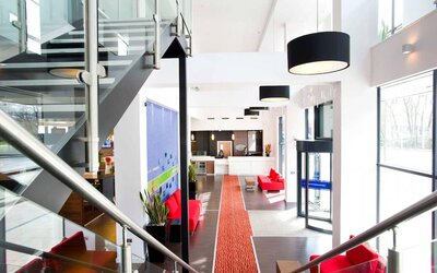 Staircase with natural light leading to reception desk. 