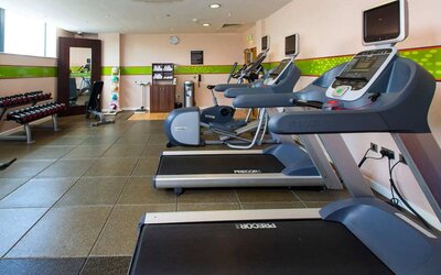 Fitness center well equipped with treadmills and step machines. 
