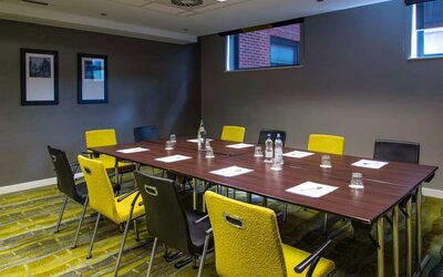 Professional meeting room with plush yellow chairs. 