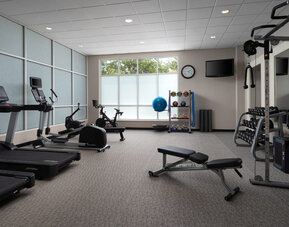 Modern fitness center featuring cardio equipment, strength-training machines, free weights, and workout space at Embassy Suites By Hilton Charleston Airport Convention Center.