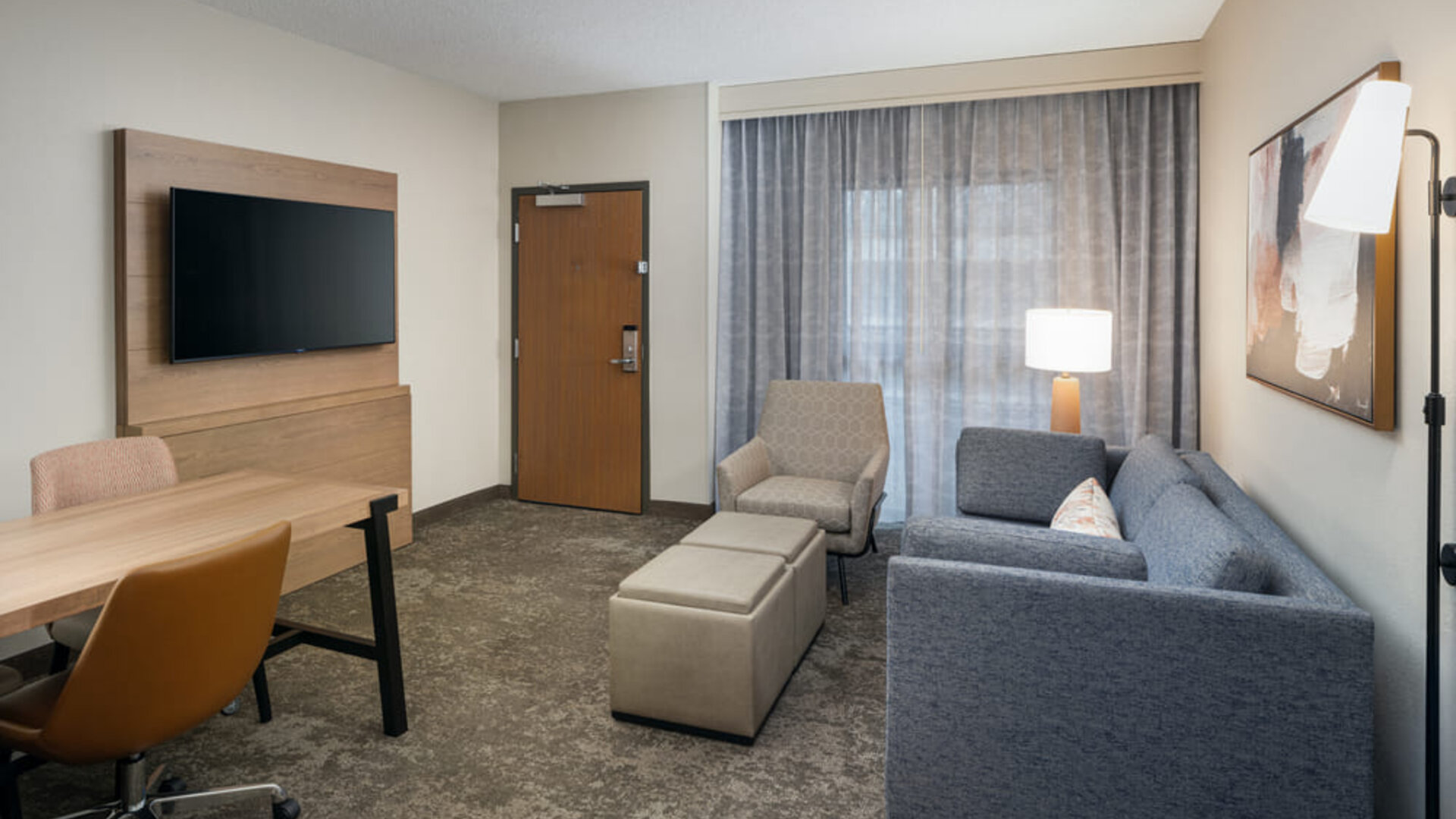Suite living area featuring a sofa, workspace, flat-screen television, and comfortable seating for extended stays at Embassy Suites By Hilton Charleston Airport Convention Center.