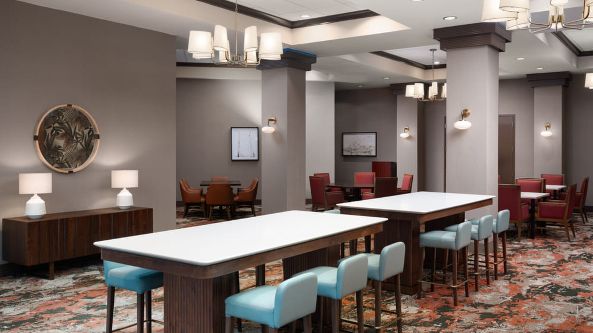 Comfortable dining and lounge area with communal seating, modern furnishings, and an inviting atmosphere at Embassy Suites By Hilton Charleston Airport Convention Center.