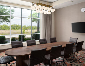 Executive boardroom with large conference table, ergonomic seating, and natural light for productive meetings at Embassy Suites By Hilton Charleston Airport Convention Center.
