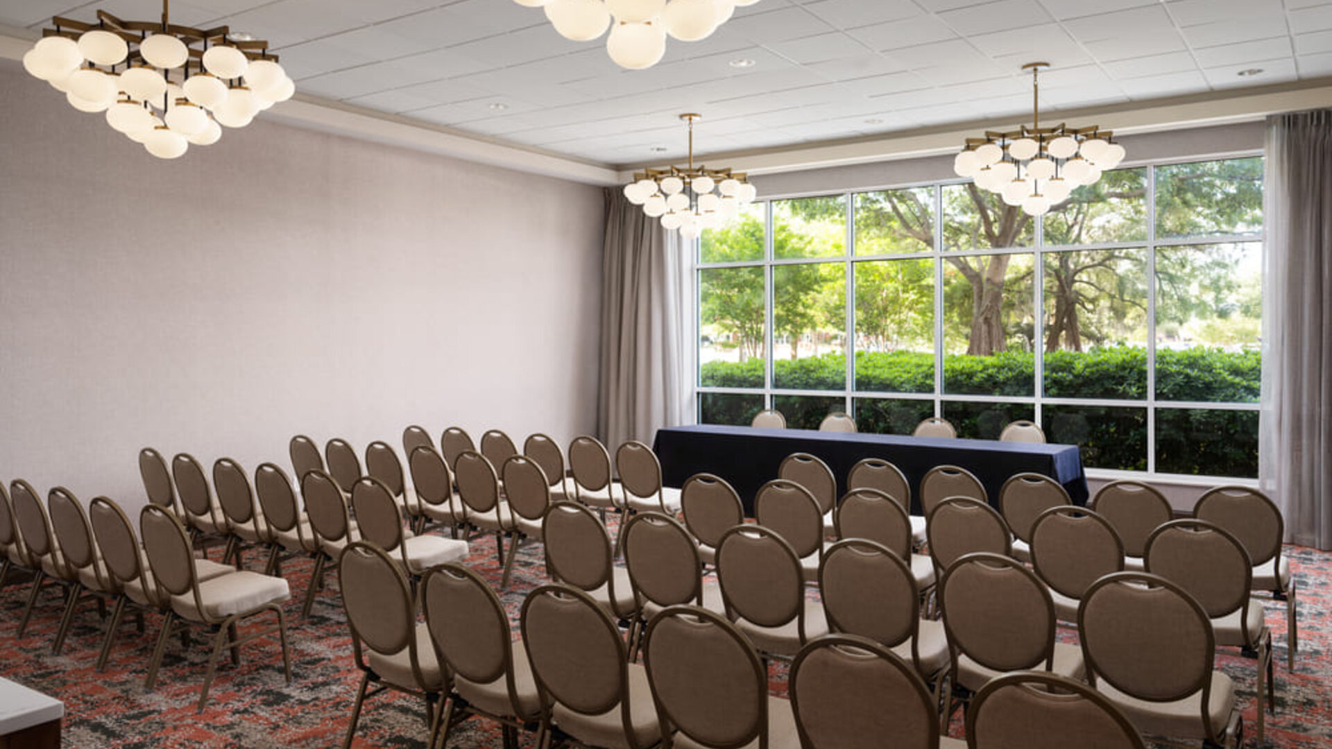 Conference and event space arranged in theater style, ideal for presentations, seminars, and corporate events at Embassy Suites By Hilton Charleston Airport Convention Center.
