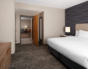Private king bedroom featuring plush bedding, contemporary furnishings, and a separate suite layout for added comfort and privacy at Embassy Suites By Hilton Charleston Airport Convention Center.