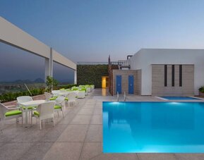 Relaxing outdoor pool area at the DoubleTree by Hilton Jaipur Amer.
