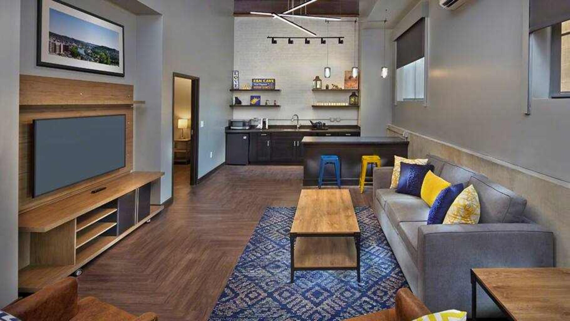 Living room with sofa and TV screen at the Tapestry By Hilton Scholar Morgantown, WV.