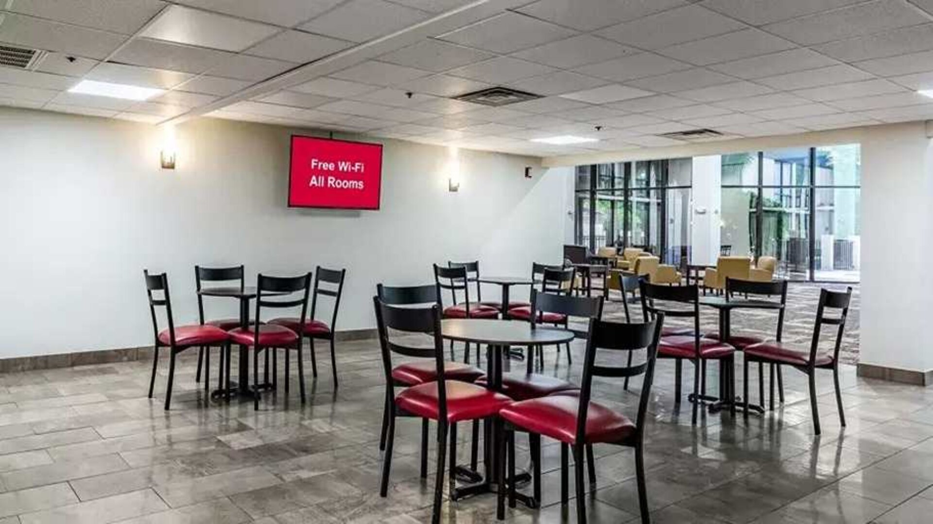Open-plan dining and coworking space at Red Roof PLUS+ & Suites Houston - IAH Airport SW.