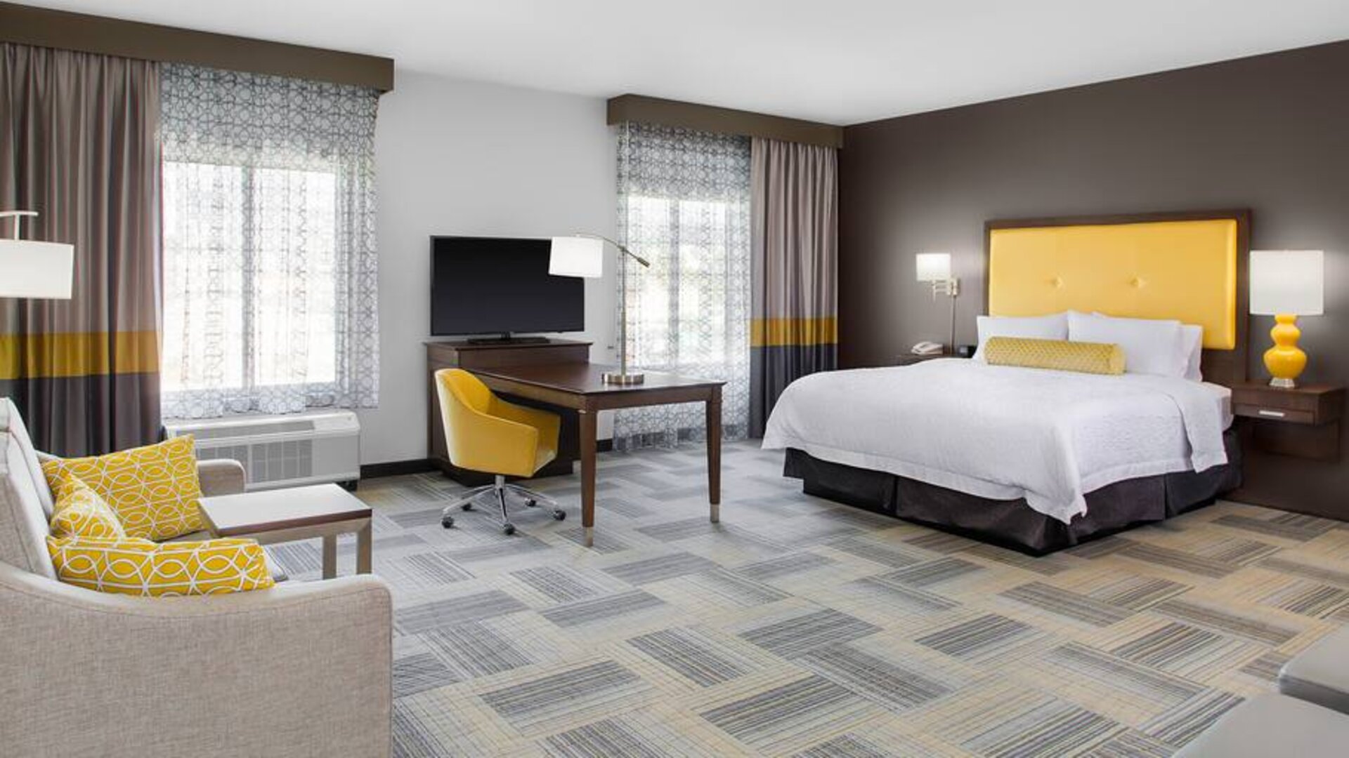 Spacious king bedroom with sofa at Hampton Inn & Suites Los Angeles/ Hollywood.