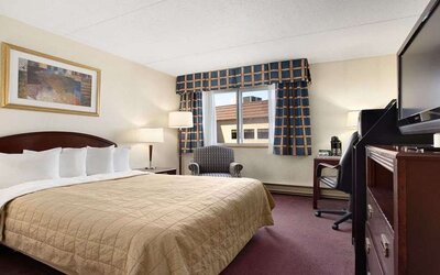 Hotel bedroom with TV screen and desk at Travelodge Ottawa East.