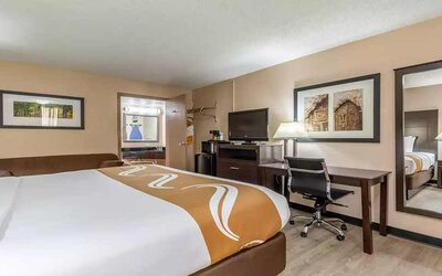 King bedroom with business desk and TV at Quality Inn Pasadena.