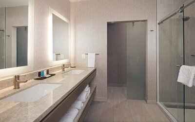Guest bathroom with shower at H Hotel Los Angeles, Curio Collection By Hilton.
