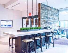 Comfortable open plan seating with plug points for laptops ideal for working remotely at Courtyard By Marriott New York JFK Airport.