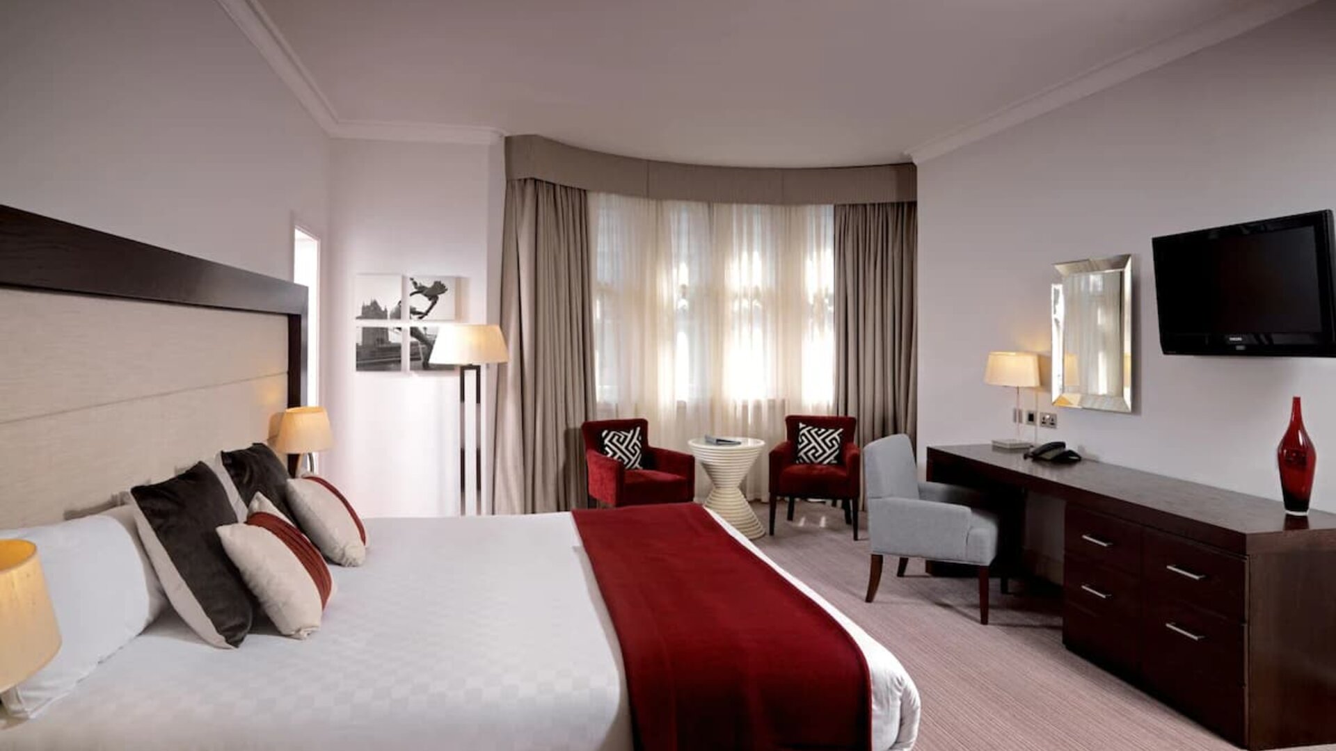 King-sized bed in the executive king room, with a desk workspace and television.