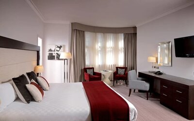 King-sized bed in the executive king room, with a desk workspace and television.