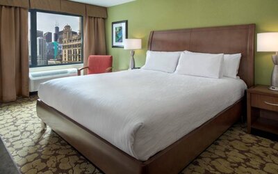 Double bed guest room within the Hilton Garden Inn Chicago Downtown Riverwalk, with city views through the large window.