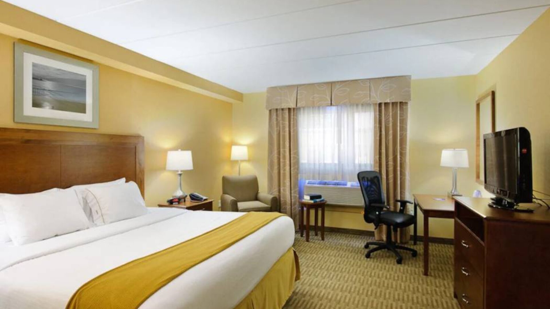 Guest room in Holiday Inn Express Philadelphia Airport, with double bed and chair/desk for working.