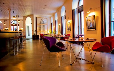 The hotel restaurant has a bar and small tables for diners to enjoy a refined breakfast experience.