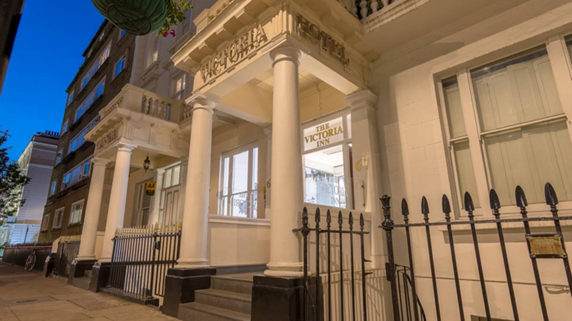 The nocturnal exterior of the Victoria Inn, including stylish white columns.