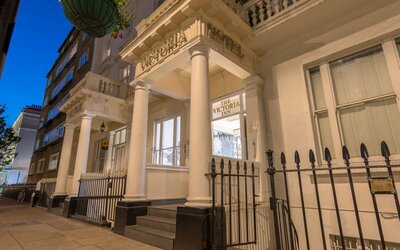 The nocturnal exterior of the Victoria Inn, including stylish white columns.