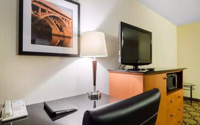 Guest room in the Comfort Inn Saskatoon, with workspace desk and chair and nearby TV.