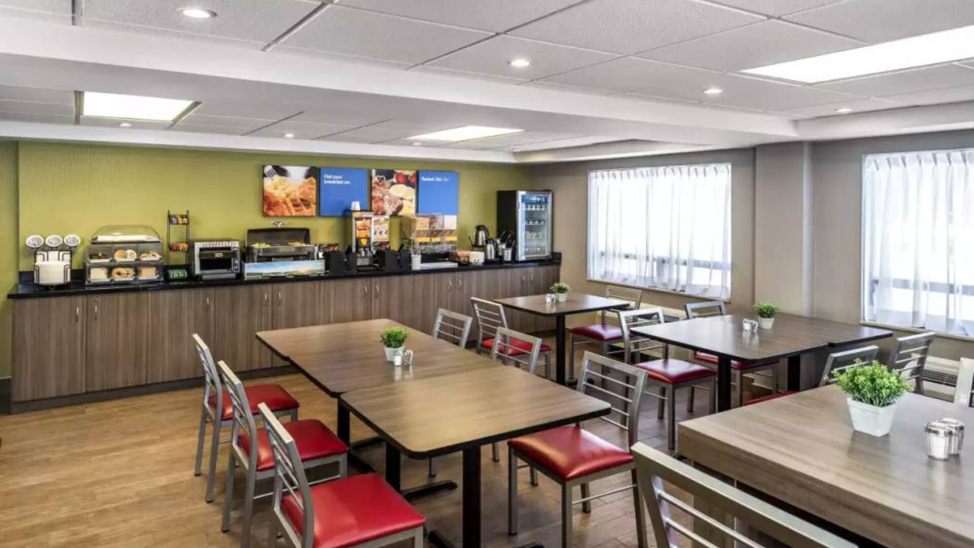 The Comfort Inn Saskatoon’s breakfast area has a hard floor and assorted table sizes.