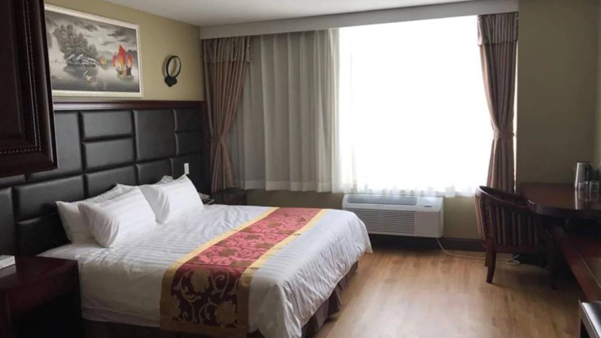 Queens Hotel guest room, including table, chair, window, and large double bed.