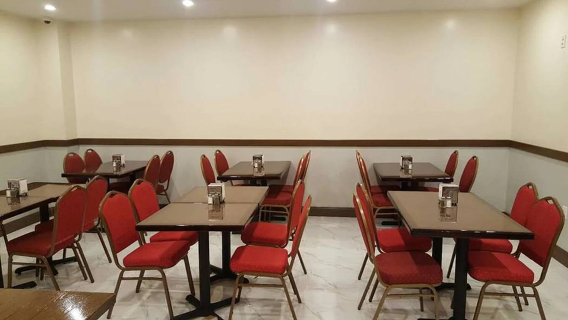 The hotel’s breakfast area, with hard floor and small tables.