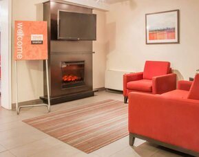 The hotel’s lobby has comfortable seating, a fireplace, and large TV screen.