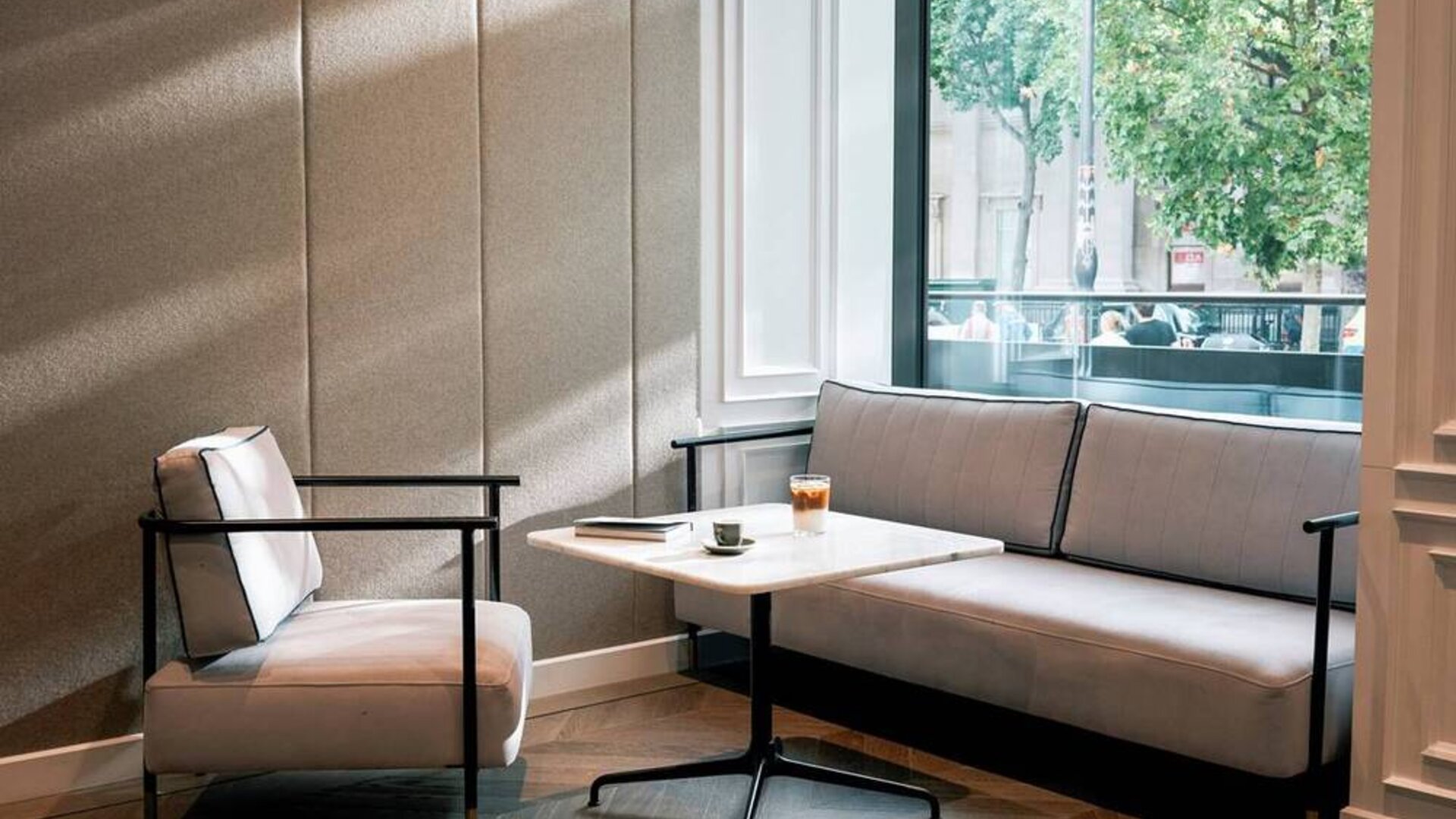 A place to relax in the Page8 hotel, with sofa, chair, and coffee table right by the window.