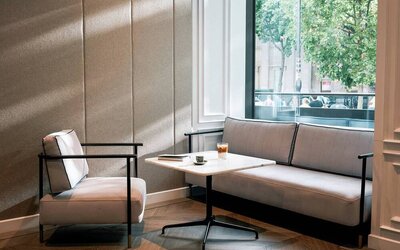 A place to relax in the Page8 hotel, with sofa, chair, and coffee table right by the window.