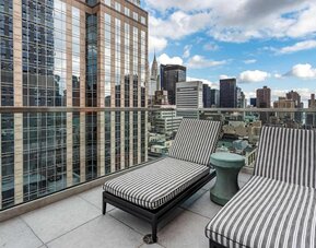 Panoramic city views from a guest room balcony in The Draper, Ascend Hotel Collection, with a pair of loungers.