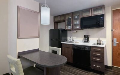 The kitchenette area in a guest room of Candlewood Suites Times Square, including fridge, oven, and microwave.