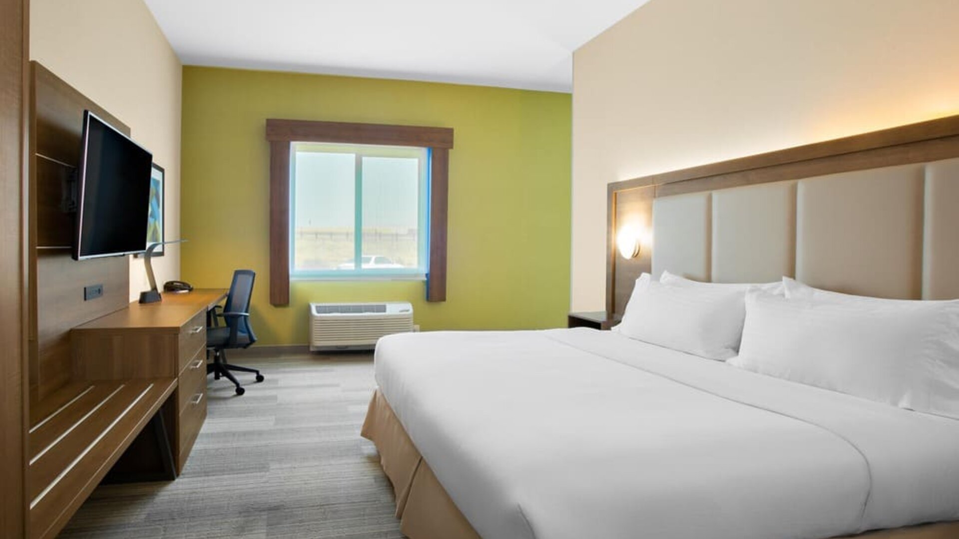 Comfortable king bedroom with TV and business desk at Holiday Inn Express & Suites Ontario.