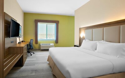 Comfortable king bedroom with TV and business desk at Holiday Inn Express & Suites Ontario.