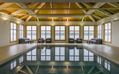 The hotel’s indoor pool has armchairs and sofas nearby.