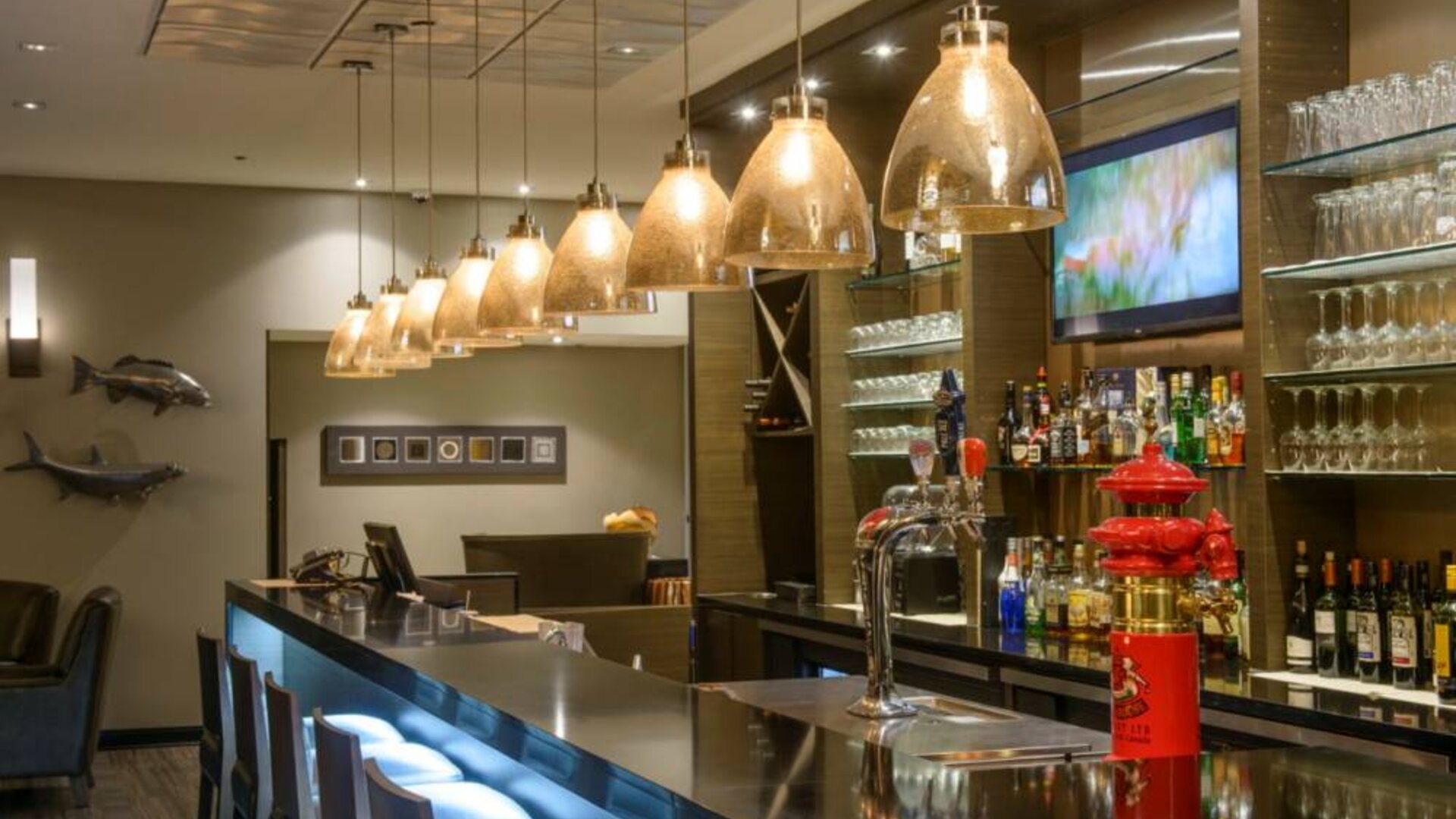 The hotel’s bar has tall stools, art on the wall, and a broad selection of beverages.