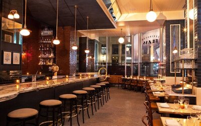 Hotel 48LEX New York’s bar and restaurant, with small tables and tall bar stools.