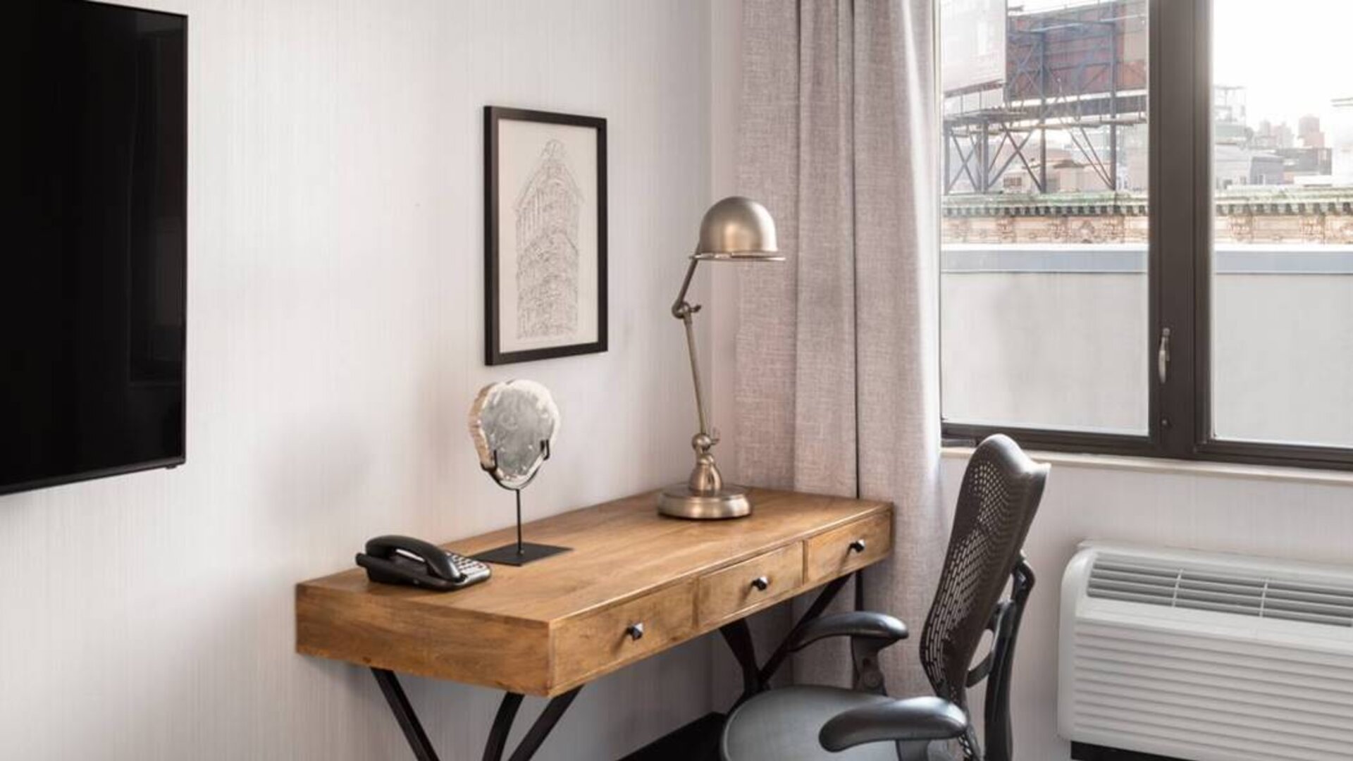 An in-room work station at the Hilton Garden Inn Tribeca, with lamp, chair, and desk.