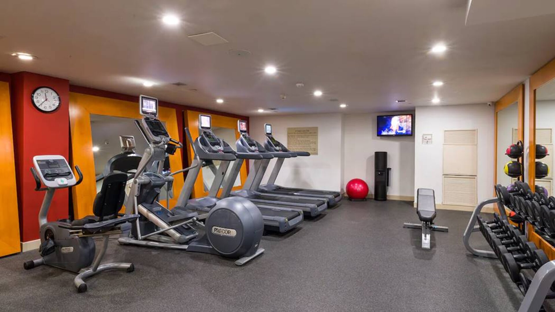 The hotel fitness center, which is equipped with weights, an exercise bench, and multiple machines.