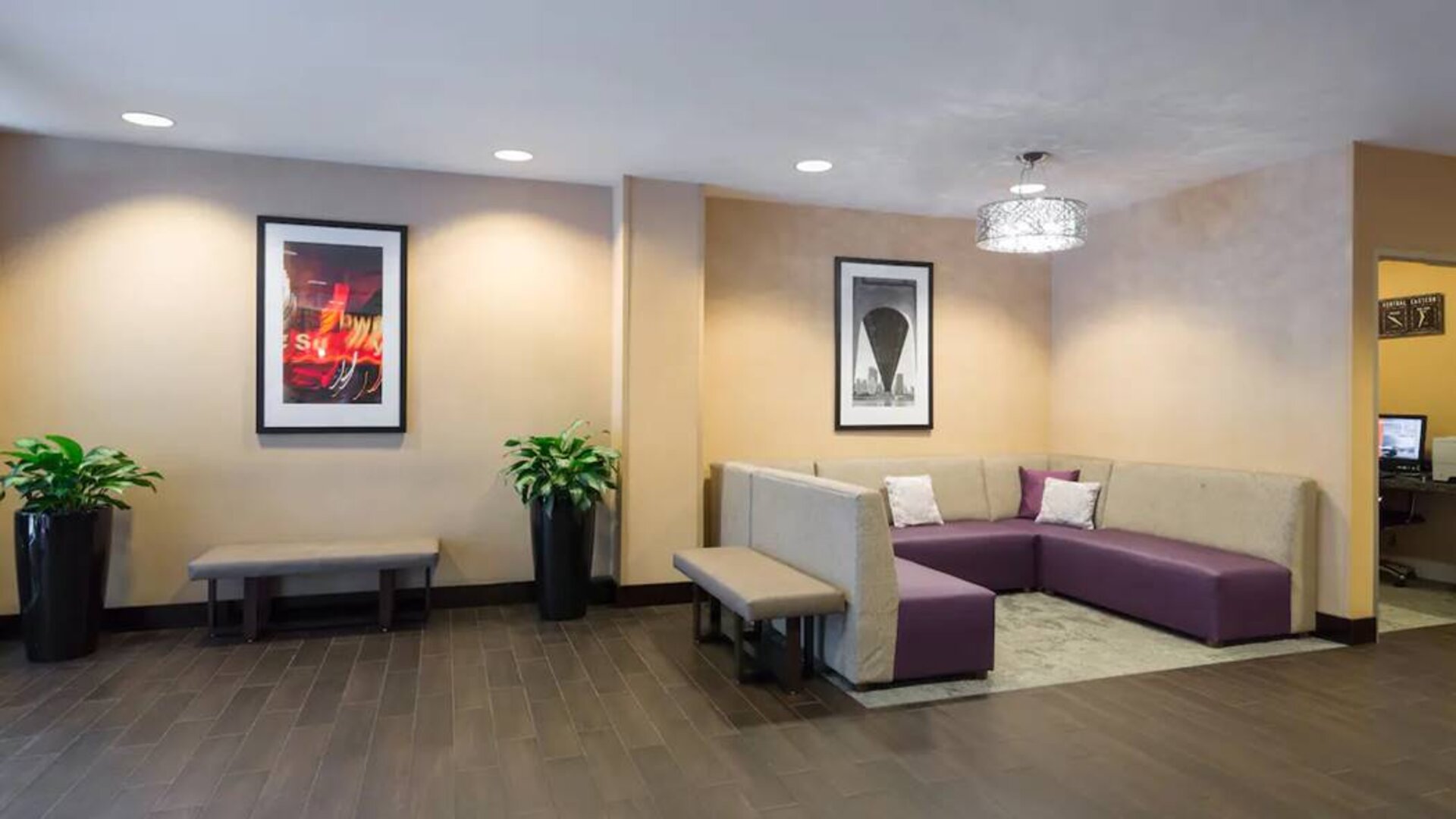 Hampton Inn Times Square South’s lobby lounge, with art on the walls and comfortable sofa seating.